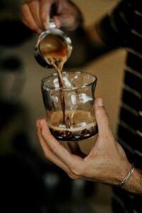 Hands pouring freshly brewed coffee into a glass. Captured in Baku, Azerbaijan.