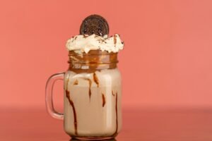 Indulge in a creamy chocolate milkshake topped with whipped cream and an Oreo cookie.