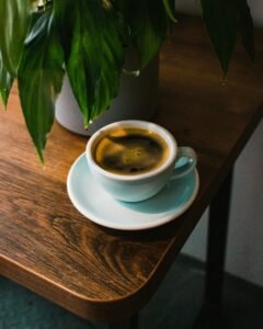 Warm and inviting coffee moment with a fresh brew on a wooden table beside a green plant.